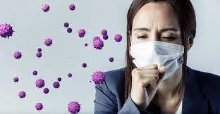 A woman with a mask on and purple viruses