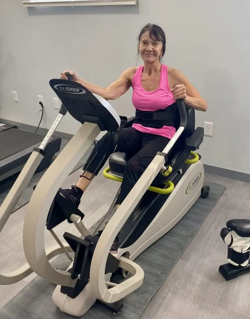 A woman is sitting on an exercise bike